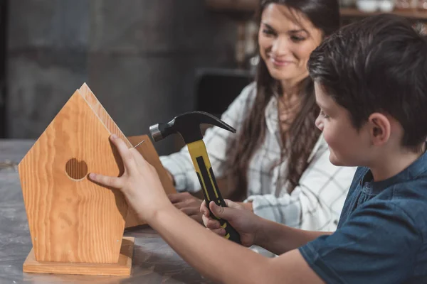 Madre e hijo construyendo pajarera - foto de stock