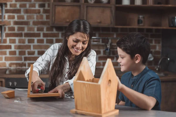 Mutter und Sohn bauen Vogelhaus zusammen — Stockfoto