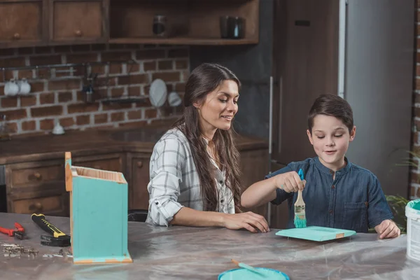 Mother and son painting birdhouse — Stock Photo