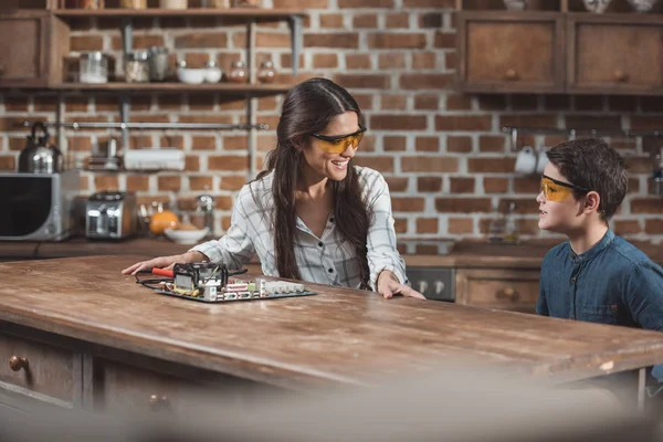 Mother and son working on mothernoard — Stock Photo