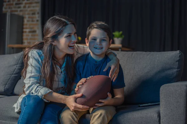 Hugging mother and son watching rugby — Stock Photo