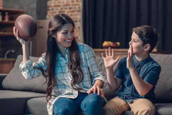 Mère et fils jouant avec la balle de rugby — Photo de stock