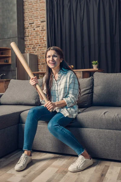 Mulher com morcego assistindo beisebol na tv — Fotografia de Stock