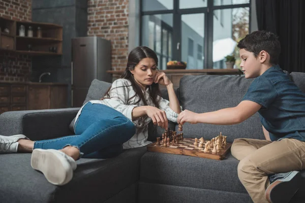 Madre y niño jugando ajedrez - foto de stock