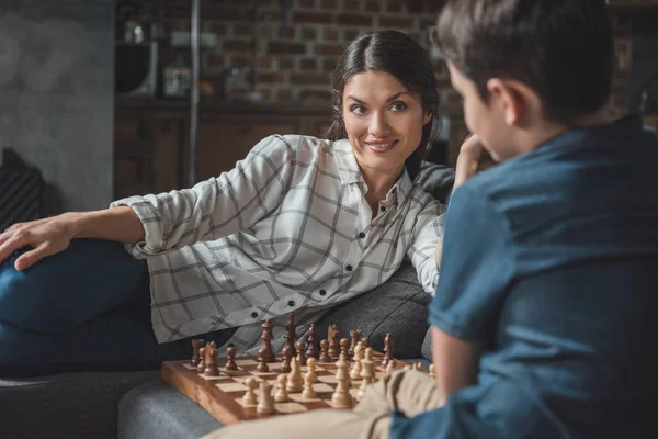 Madre y niño jugando ajedrez - foto de stock