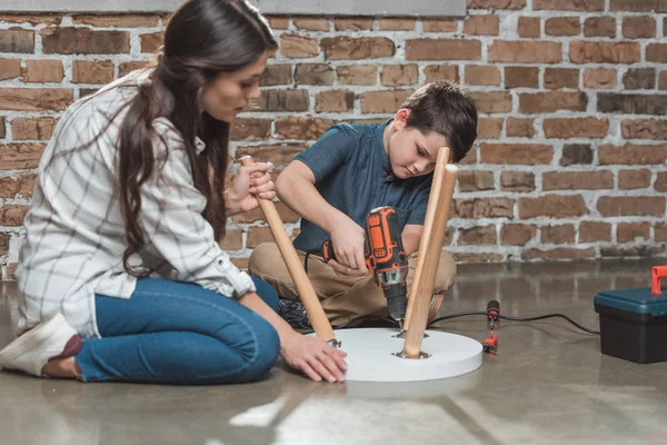 Mother and son assembling table — Stock Photo