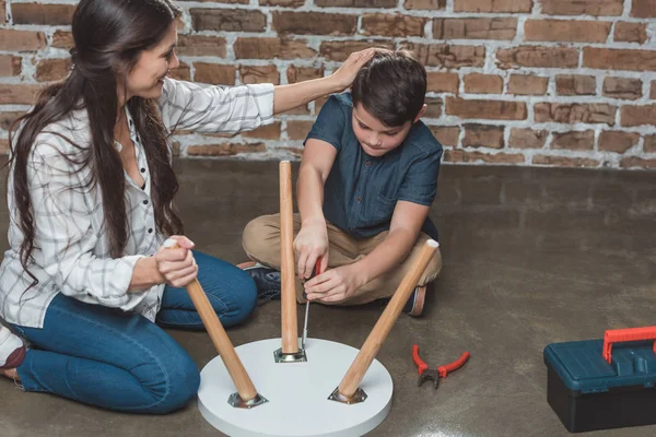 Family assembling coffee table — Stock Photo