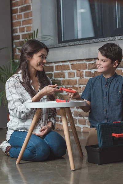 Woman giving pliers to son — Stock Photo