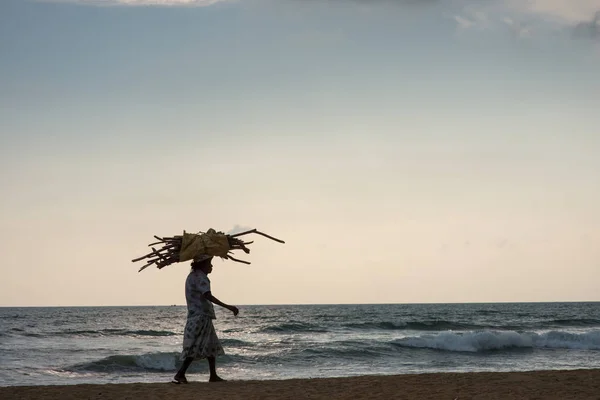 Mulher velha andando pela praia — Fotografia de Stock
