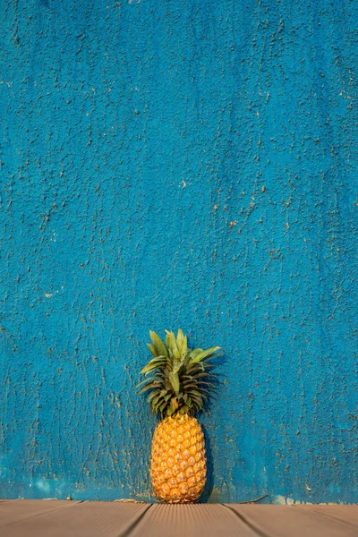 Pineapple in front of blue wall — Stock Photo