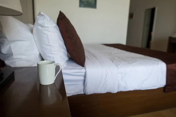 Cup of coffee on nightstand — Stock Photo