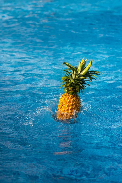 Piña cayendo en el agua - foto de stock