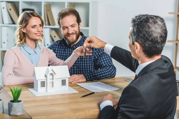 Couple obtenir des clés de l'agent immobilier — Photo de stock