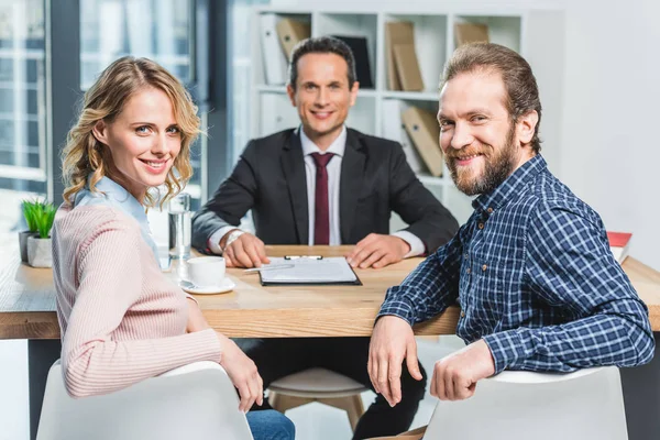 Smiling couple and lawyer — Stock Photo