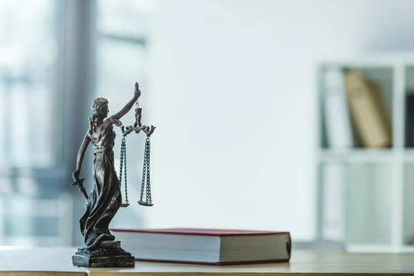 Femida and book on tabletop — Stock Photo