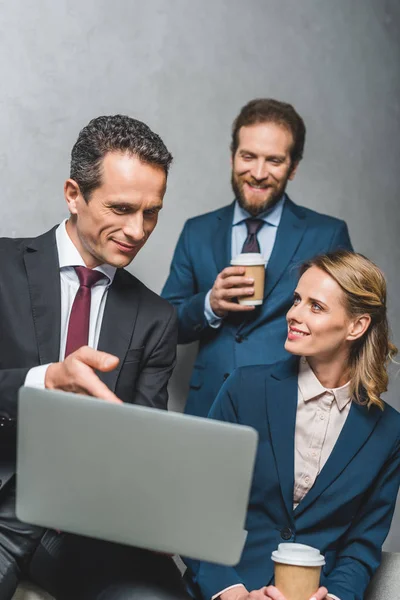 Colegas usando el ordenador portátil juntos - foto de stock