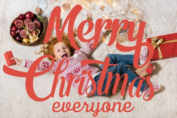 Kid lying on floor with gifts — Stock Photo