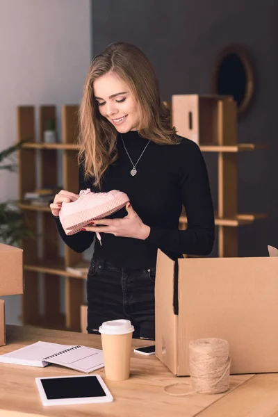 Portrait of beautiful entrepreneur packing products for customers in cardboard boxes at home office — Stock Photo