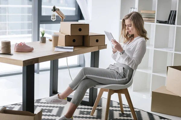 Vista laterale della giovane donna d'affari che utilizza tablet digitale mentre si siede a tavola — Foto stock