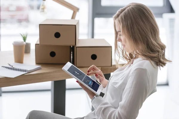 Side view of young businesswoman using digital tablet with tumblr app — Stock Photo