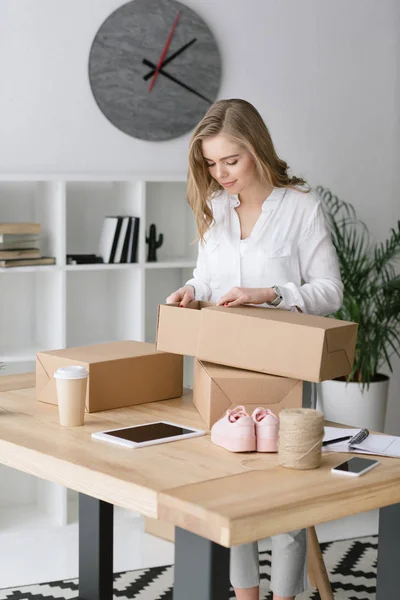 Портрет красивого підприємця упаковки продуктів в картонні коробки в домашньому офісі — стокове фото