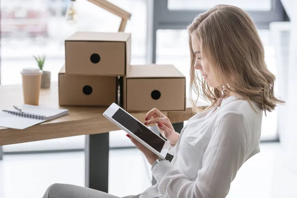 Vue latérale de la jeune femme d'affaires en utilisant une tablette numérique — Photo de stock