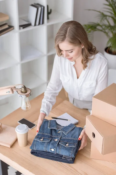 High angle view of young entrepreneur packing customers purchase at home office — Stock Photo