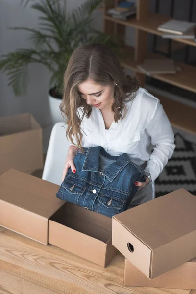High angle view of young entrepreneur packing customers purchase at home office — Stock Photo