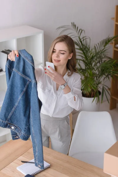 Portrait de belle femme d'affaires prenant en photo du produit sur smartphone au bureau — Photo de stock