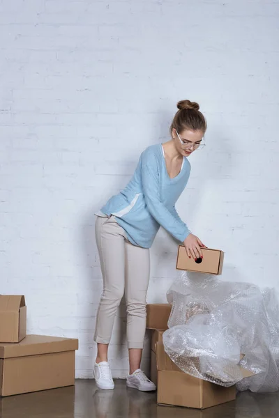 Online shop owner with cardboard boxes working at home office — Stock Photo
