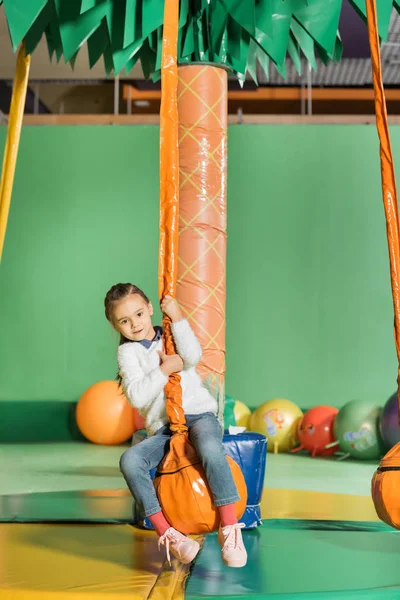 Cute little kid swinging on swing in entertainment center — Stock Photo