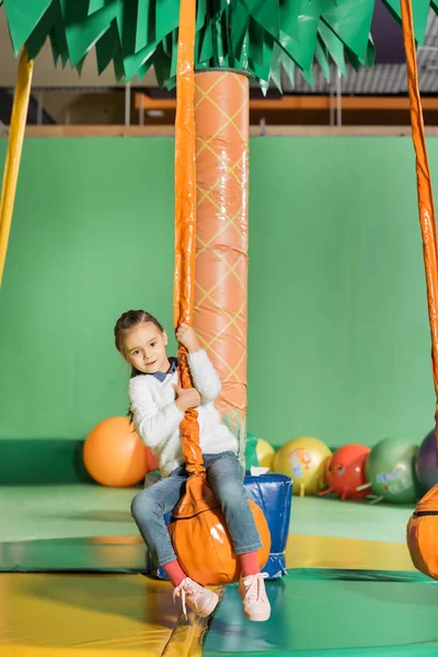 Nettes kleines Kind schaukelt auf Schaukel im Vergnügungszentrum — Stockfoto