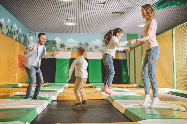 Família feliz jogando e pulando juntos no centro de entretenimento — Fotografia de Stock