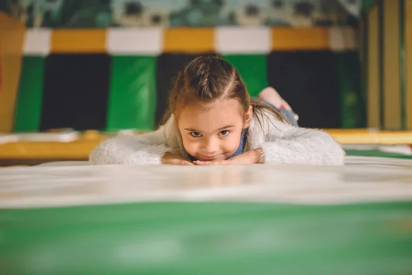 Adorable little child smiling at camera while playing in entertainment center — Stock Photo