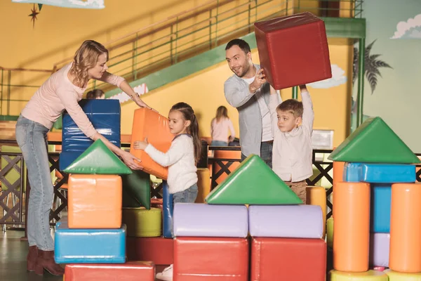 Happy family building castle with colorful blocks at entertainment center — Stock Photo