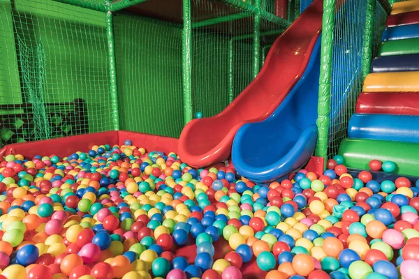 Toboggans et piscine avec des boules colorées dans le centre de divertissement — Photo de stock