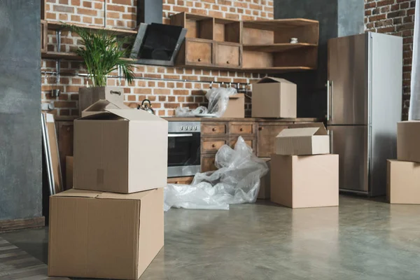 Boîtes en carton dans la cuisine vide pendant la réinstallation — Photo de stock