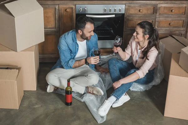 Vista de ángulo alto de feliz pareja joven bebiendo vino y celebrando la reubicación - foto de stock