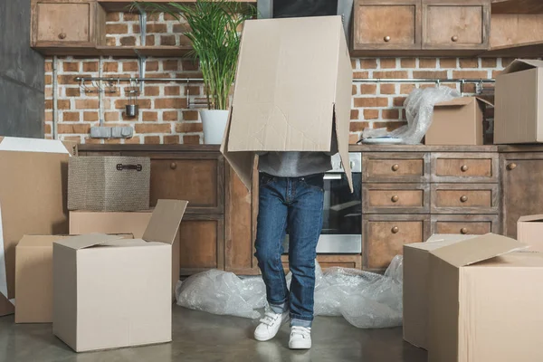 Cute little boy playing with cardboard box during relocation — Stock Photo