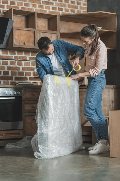 Jeune couple emballage photo tout en déménageant à la maison — Photo de stock