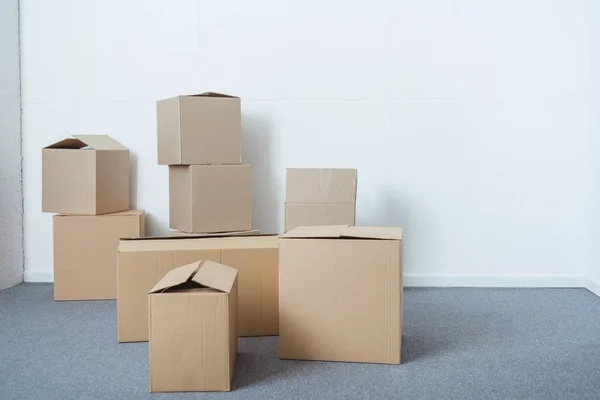 Stacks of cardboard boxes in empty room during relocation — Stock Photo