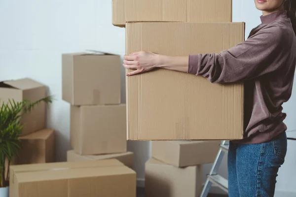 Tiro recortado de mulher segurando caixas de papelão ao se mudar para casa — Fotografia de Stock