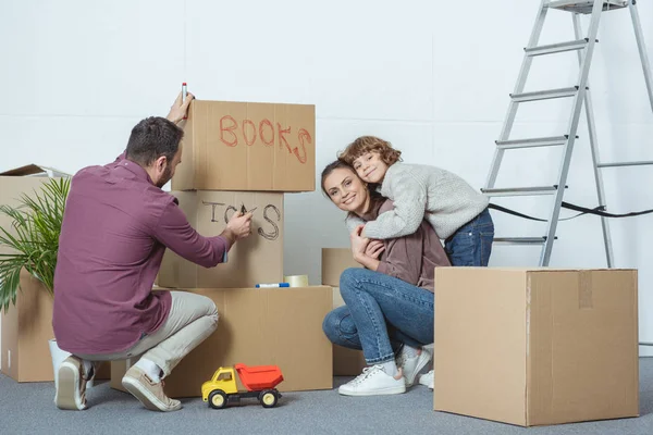 Щаслива сім'я підписує коробки під час переїзду в новий будинок — стокове фото