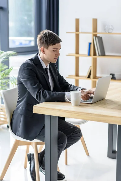 Jungunternehmer arbeitet in modernem Büro am Laptop — Stockfoto