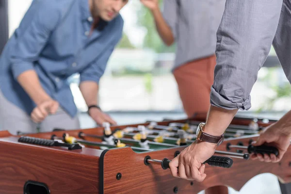 Hommes d'affaires jouant au baby-foot dans un bureau moderne — Photo de stock