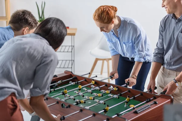 Young team playing table football in modern office — Stock Photo