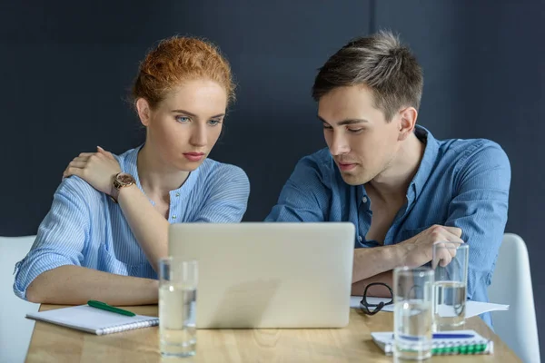 Homme d'affaires réfléchi et femme d'affaires travaillant sur un projet dans un bureau moderne — Photo de stock