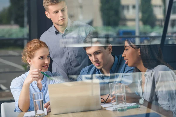 Behind the glass view of team discussing project in modern office — Stock Photo