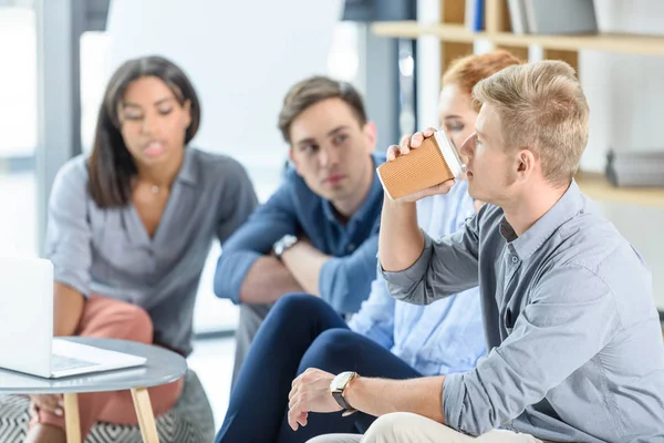 L'uomo d'affari beve caffè durante la riunione di lavoro — Foto stock