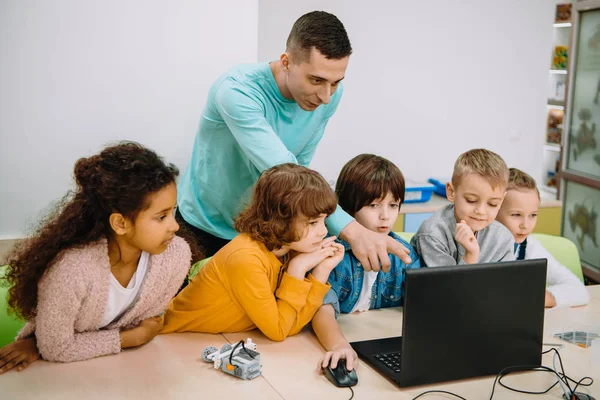 Little kids working with teacher on programming class — Stock Photo